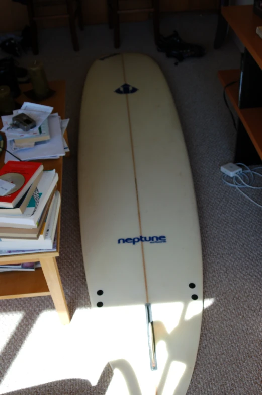 a white surfboard leaning up on a table