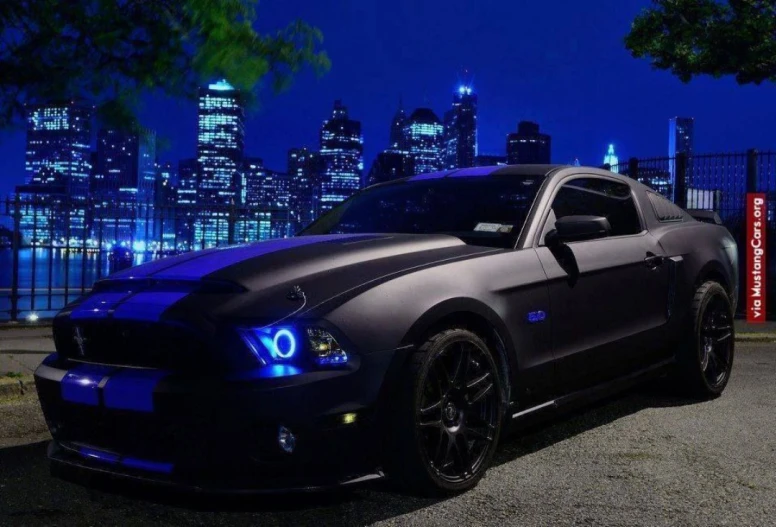 a black ford mustang in front of a cityscape