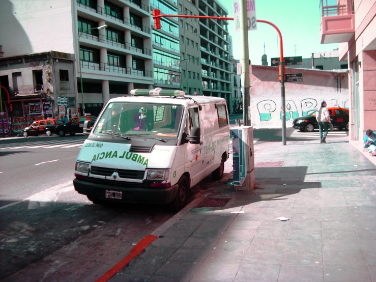 the van is parked on the sidewalk in front of the traffic signal