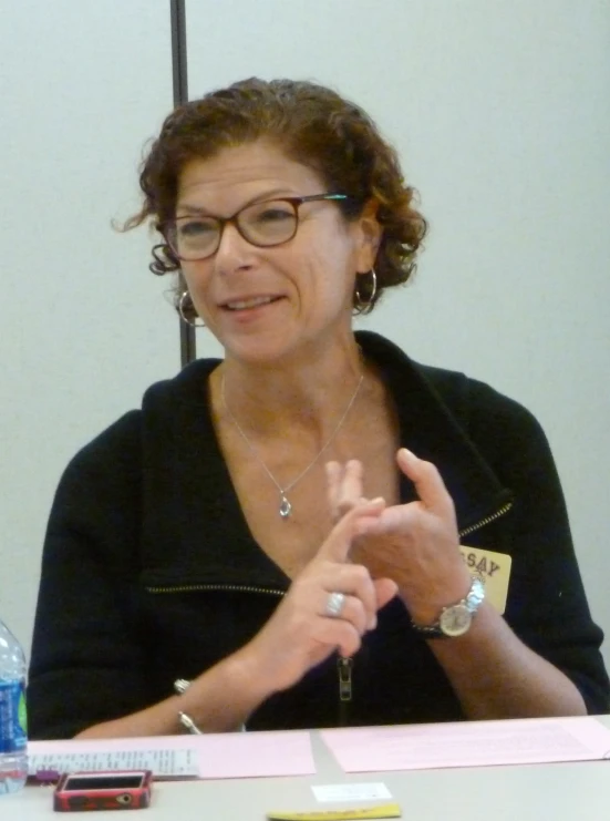 a woman in glasses is at a table talking