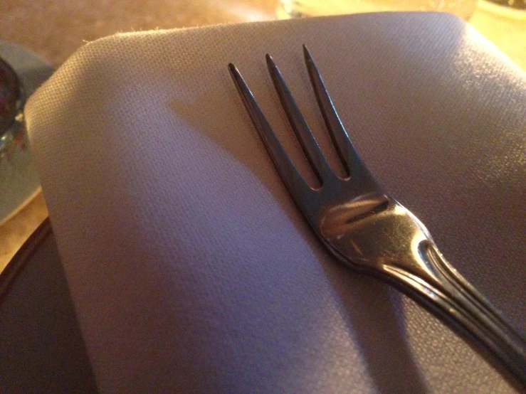 a fork rests atop a purple napkin