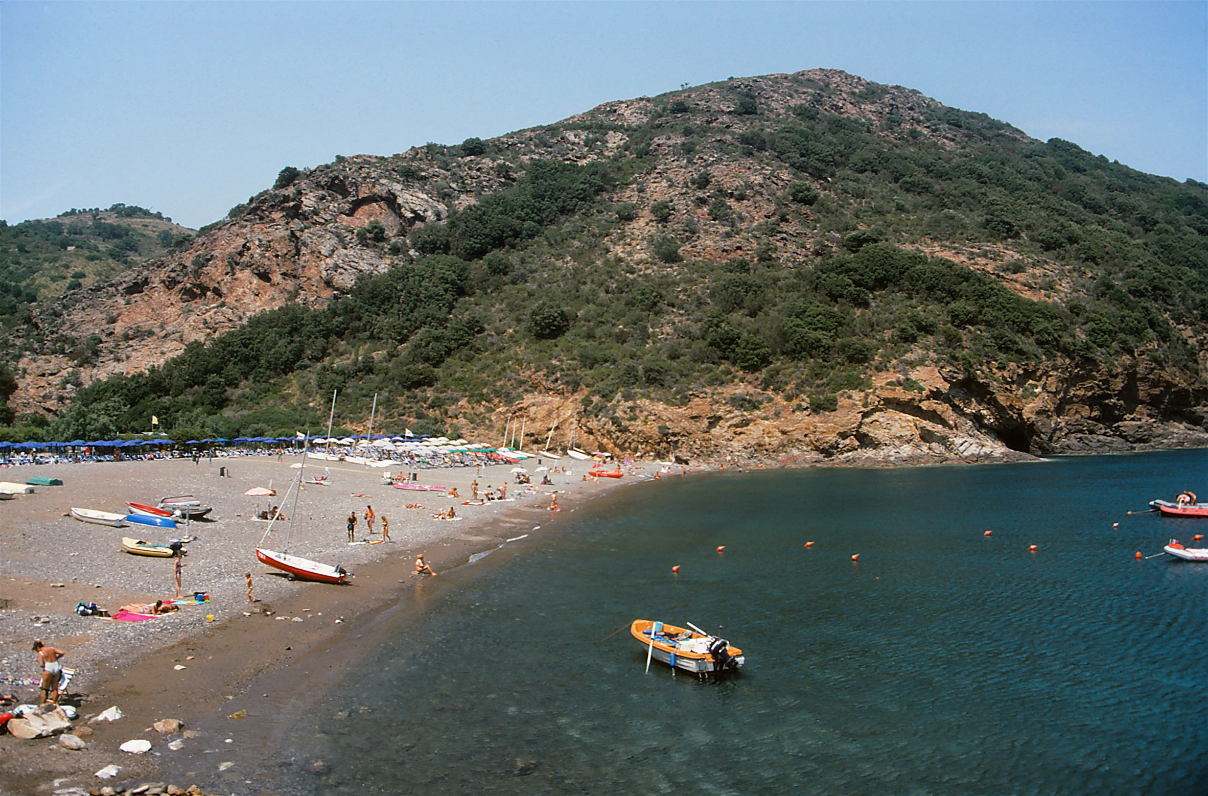 a group of people on the beach with many boats