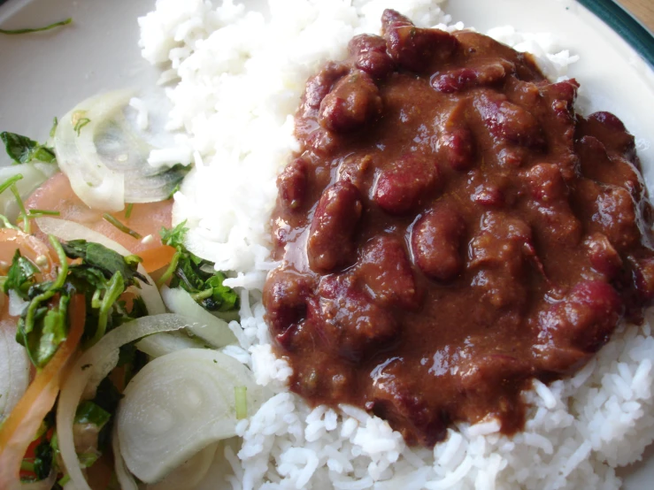 a white plate topped with rice and meat