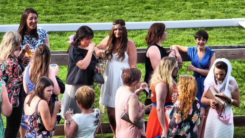 people wearing floral dress standing in front of a wooden fence