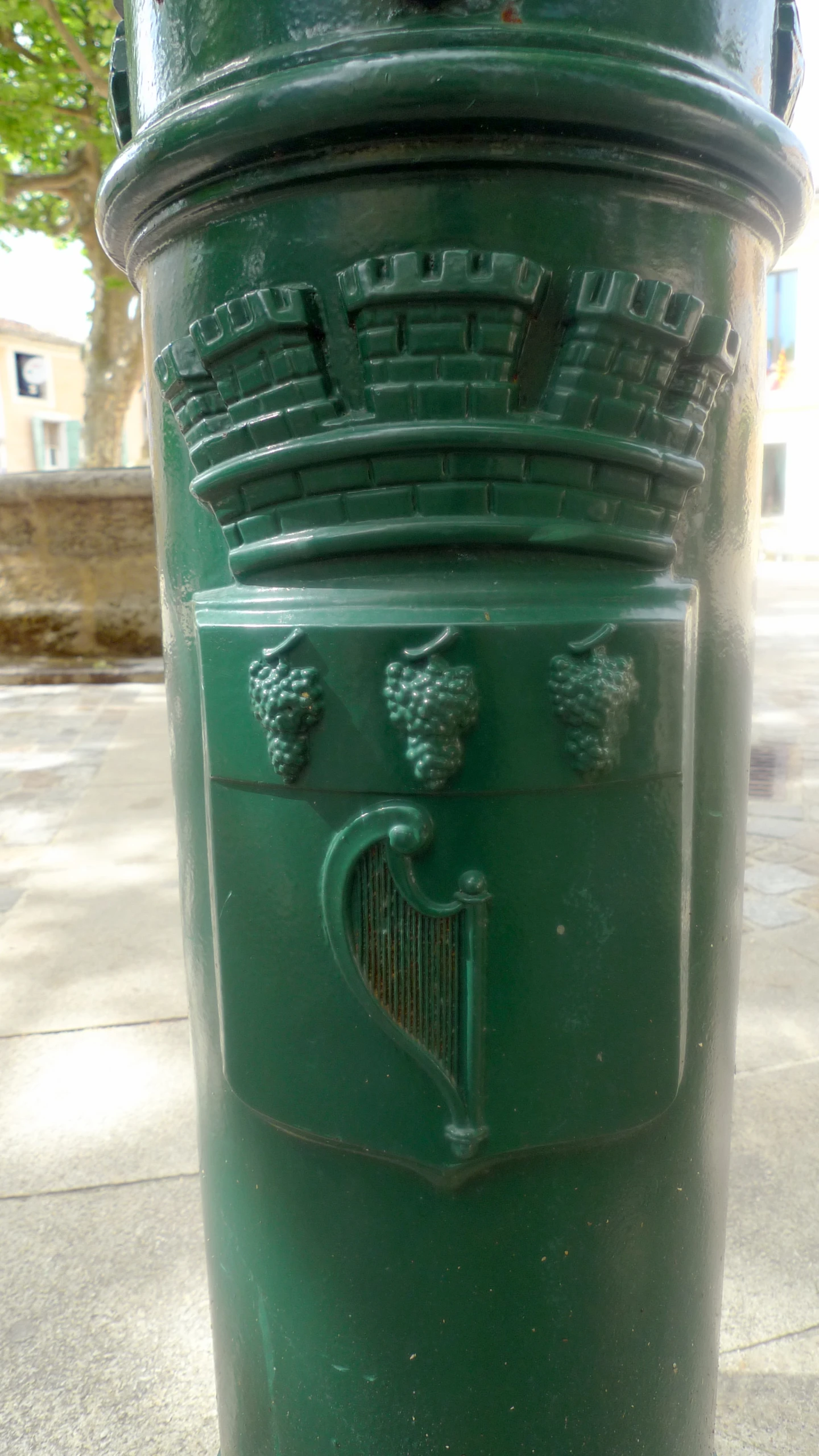 the green fire hydrant is along side a tree