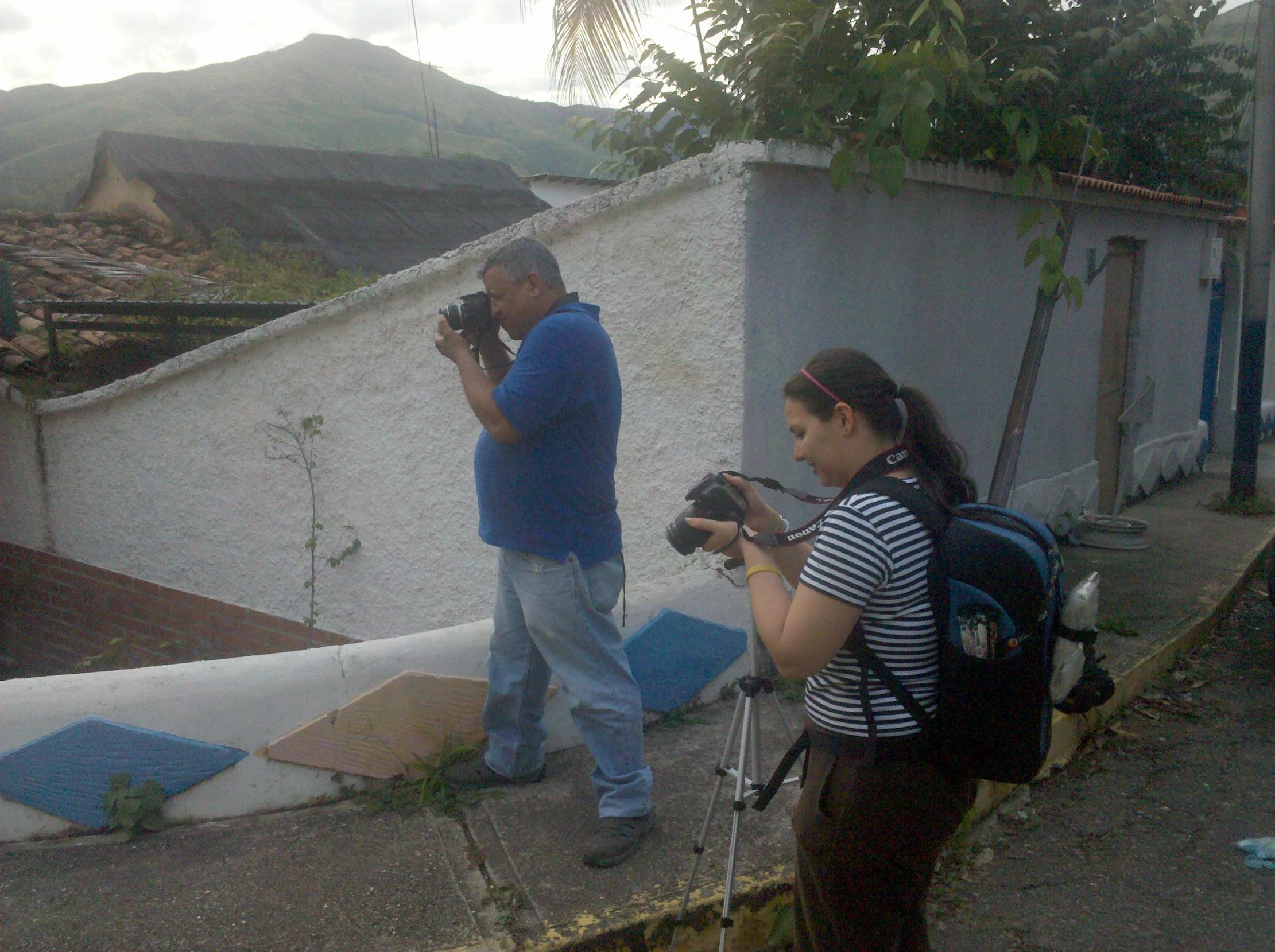 a man and woman standing outside with cameras