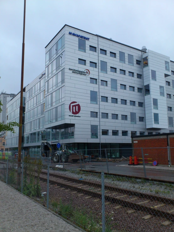 a building with windows on top next to train tracks