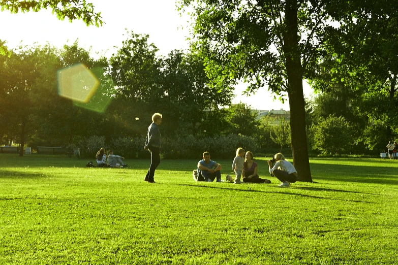 children sitting on the grass playing frisbee in the park