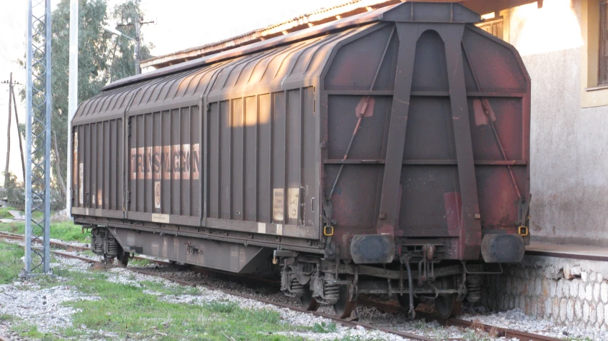 a train car is sitting on the side of a building