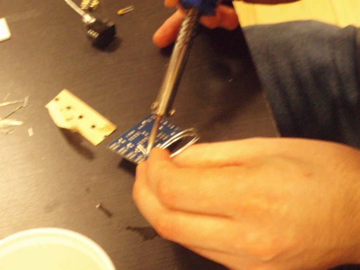 someone uses tools to repair pieces of electronics