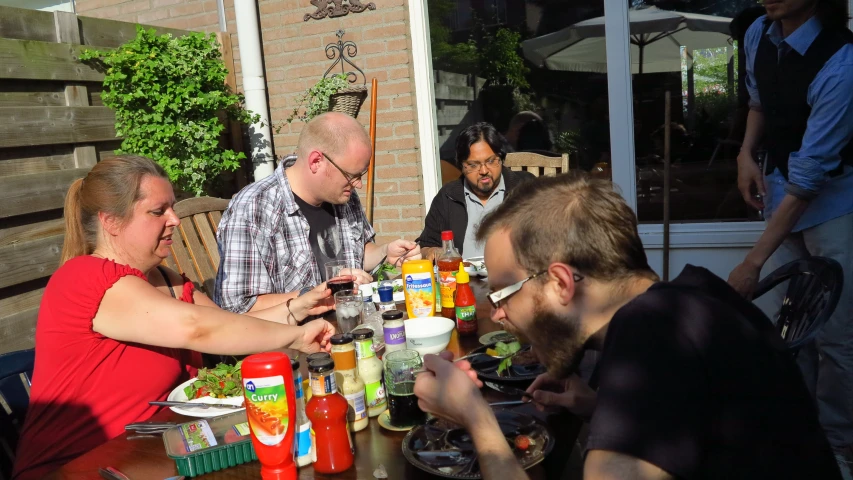 many people eating at a restaurant table with drinks