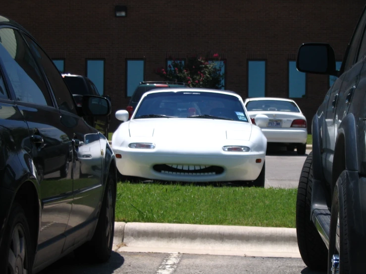 an alfa car with a dented grill sitting next to a black car