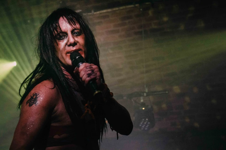 a woman singing into a microphone in front of stage lighting