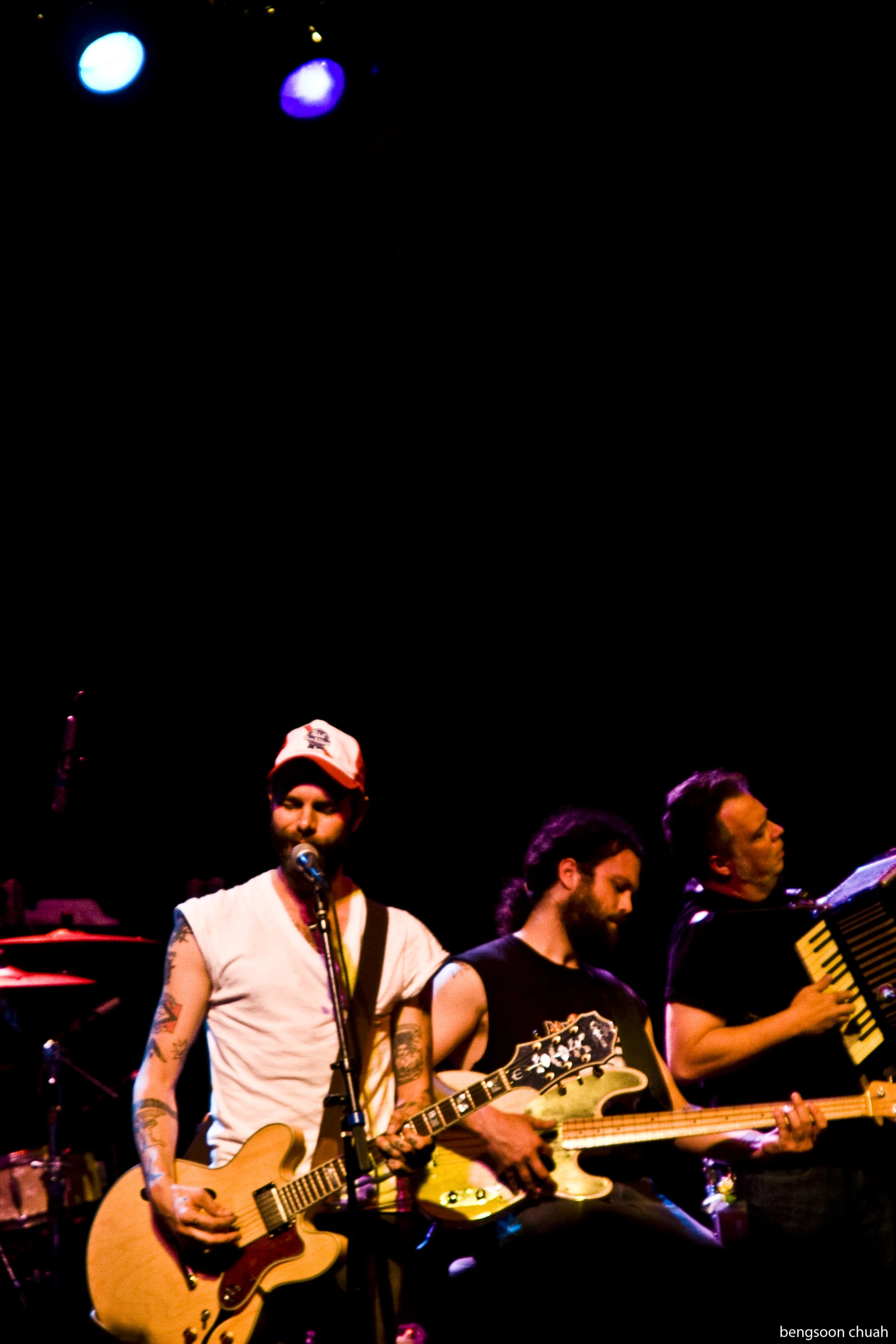 two men in white shirts playing guitar on stage