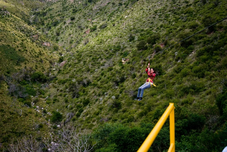 a man is on the edge of a hill near a forest