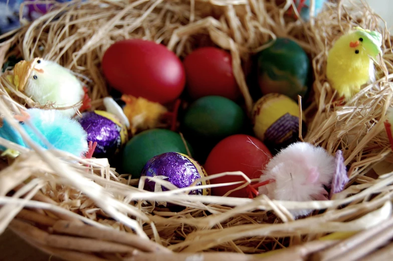 easter eggs are in a basket with straw wrapped around the top