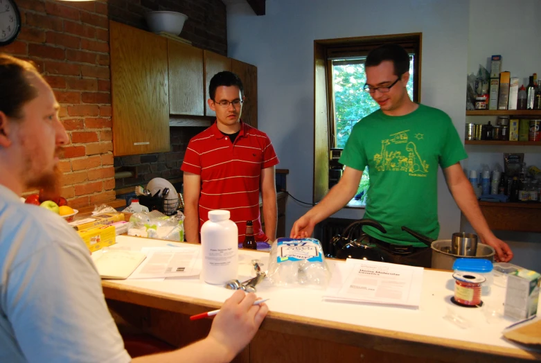 three men around a table with ingredients on them