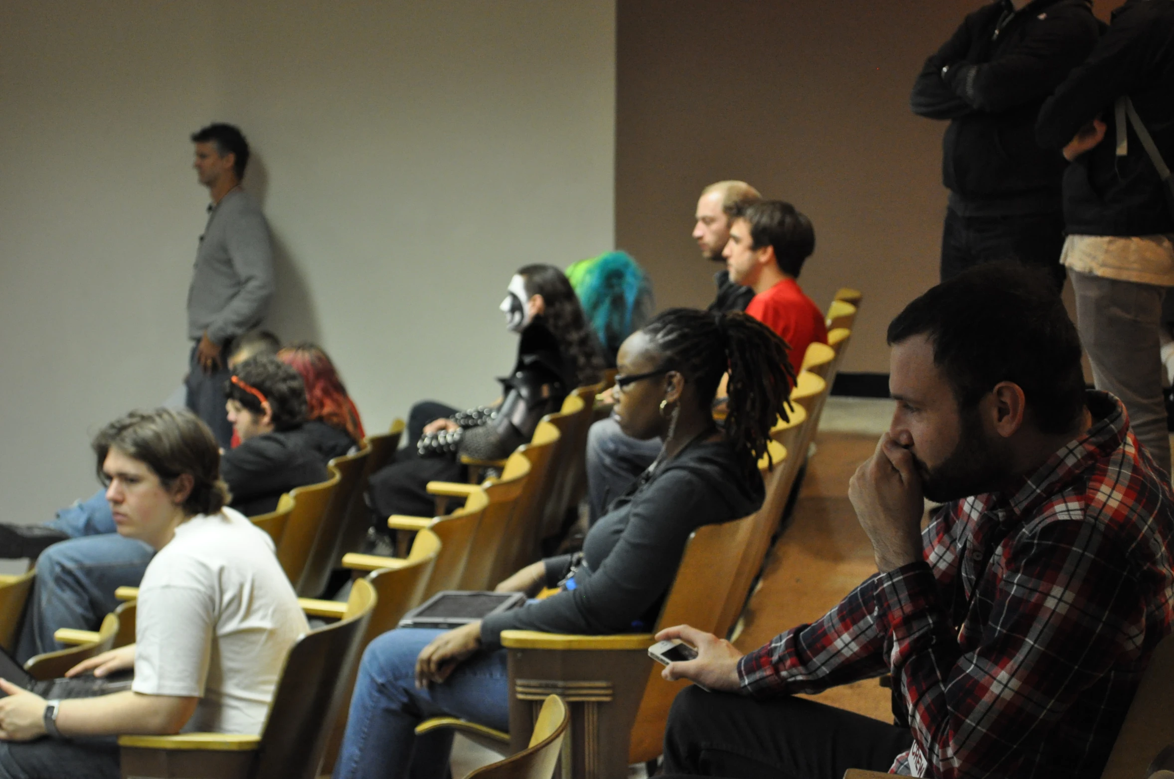 an audience watching and listening to speakers at an event