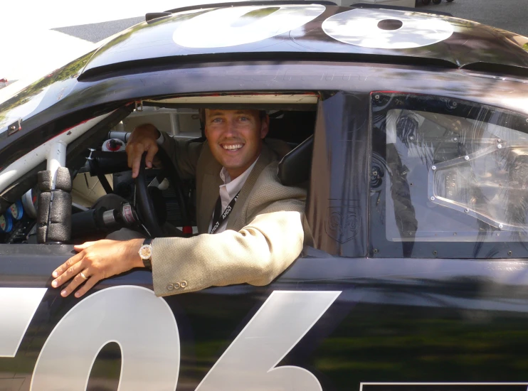 a man sitting in the drivers seat of a race car