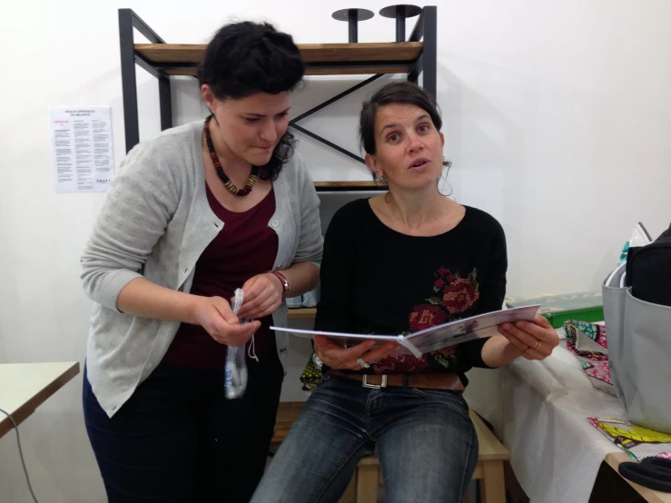 a woman holding a clipboard while standing next to a girl