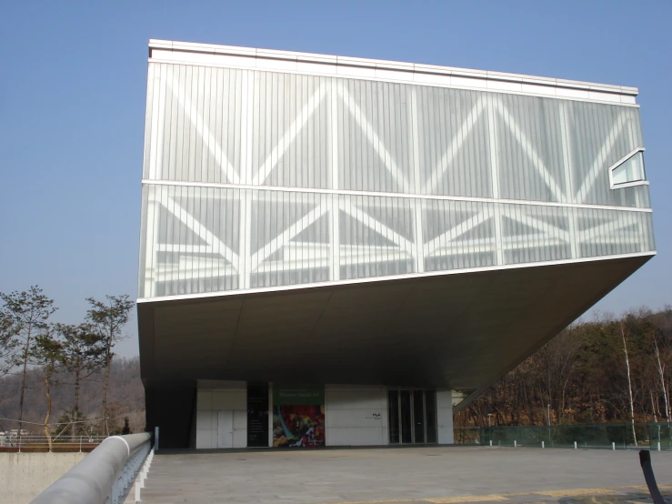 a very large white building sitting in front of trees