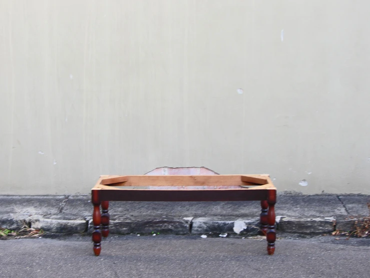 a bench sits next to a dirty wall