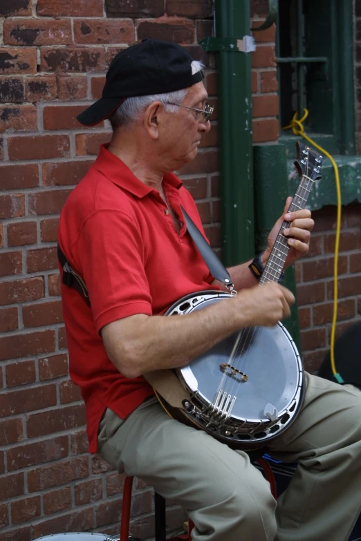 a man sitting on a chair holding an banjo