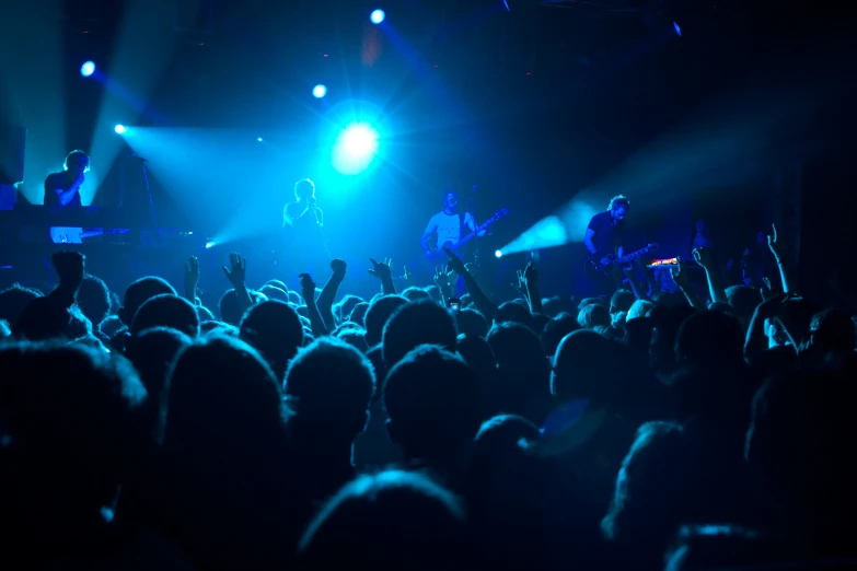 a crowd at a concert watching two musicians perform