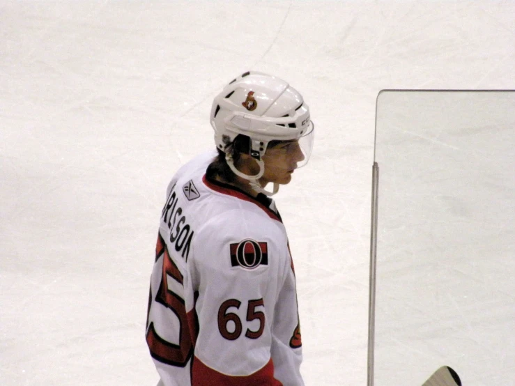 a hockey player holding a hockey stick and wearing a helmet