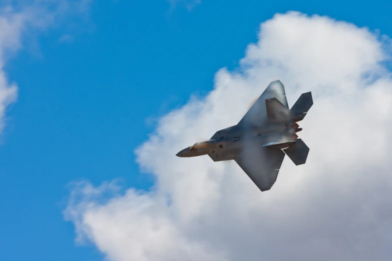 a gray fighter jet flying in the sky