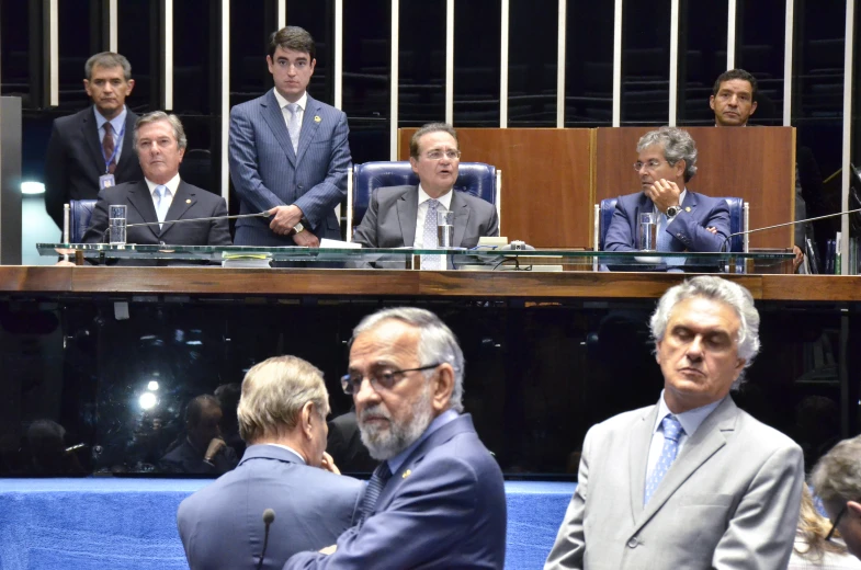 men in suits and ties sitting at a desk