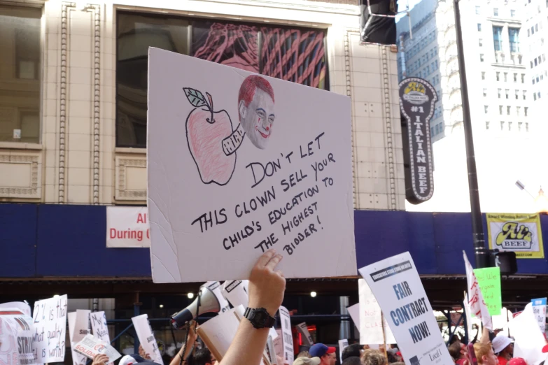 a protest with signs and a microphone in the middle of a street