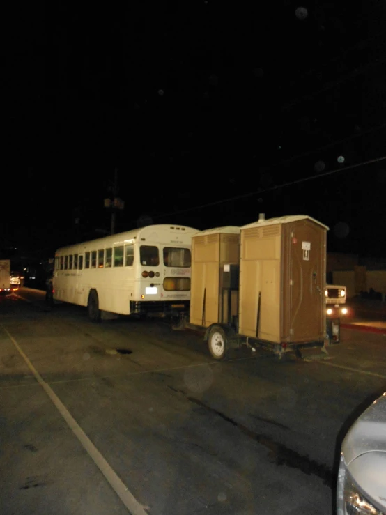 two white buses parked in parking lot next to each other