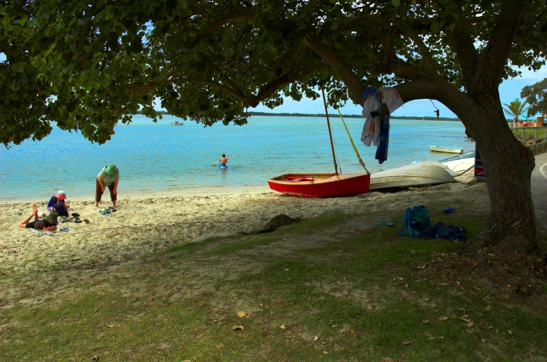 two people are standing on a beach by the water