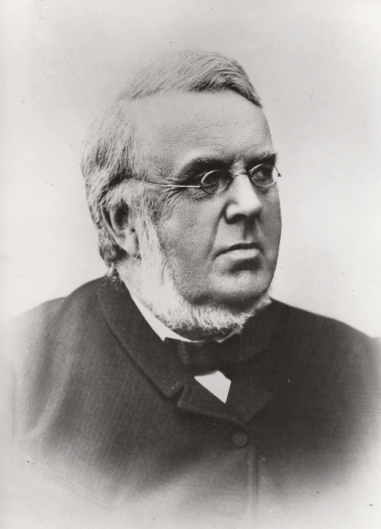 an old man wearing glasses, sitting at a desk