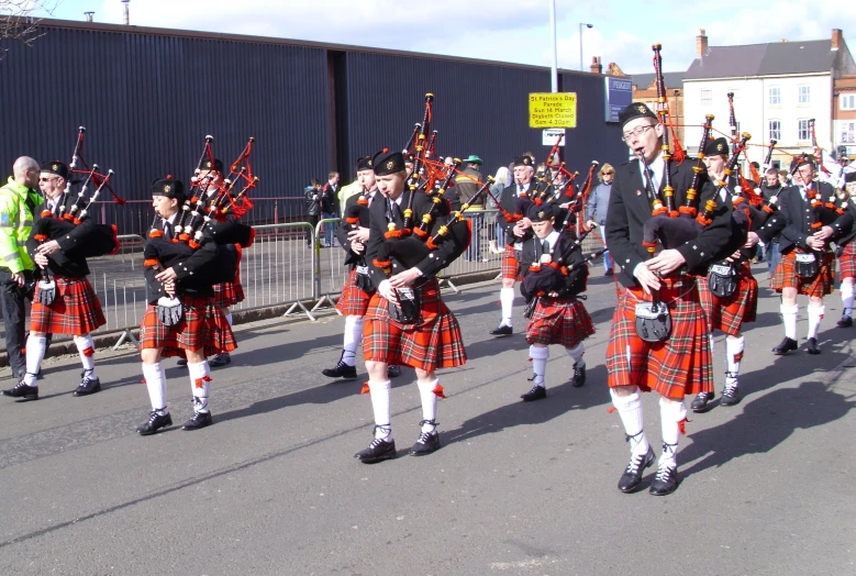 several men in tartan clothing with pipe and bagpipe