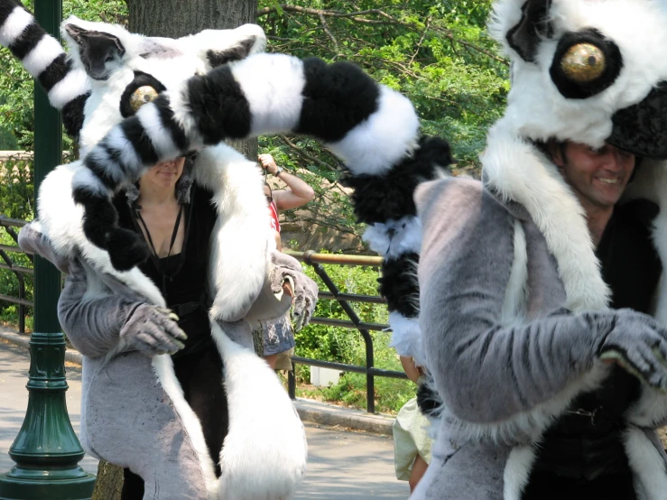 two people dressed up in animal costumes standing next to a light