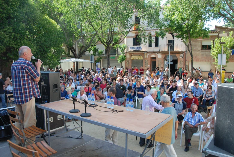 a man speaking at an outdoor music concert