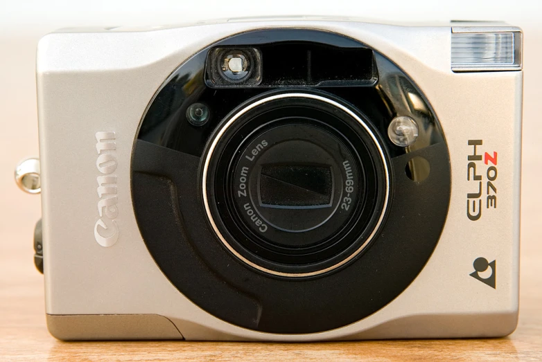 an analog camera on a wood table and on the lens with the number 11