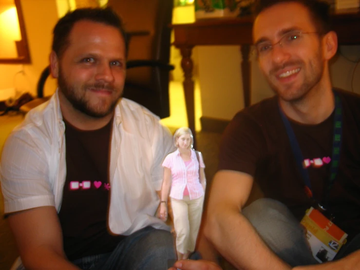 a man with a pink toy and another male sit next to him