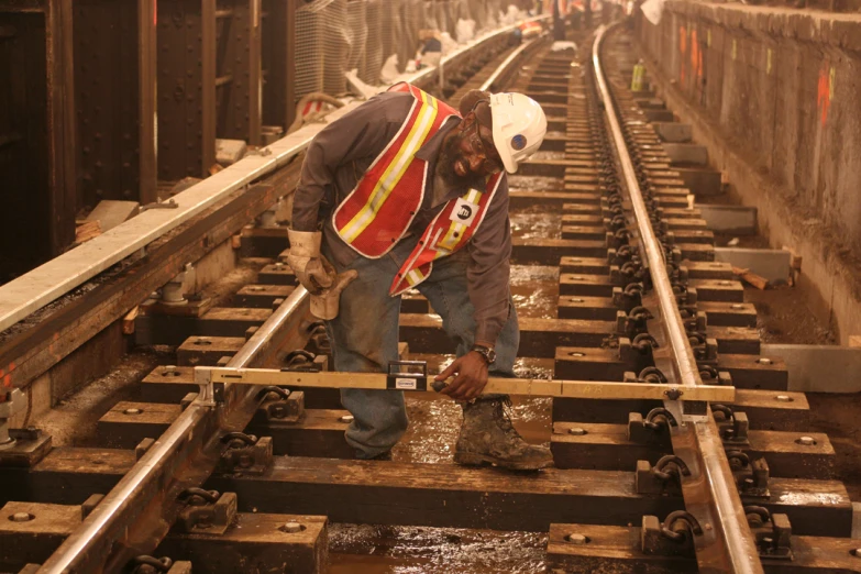 a man in an overcoat is working on a rail line