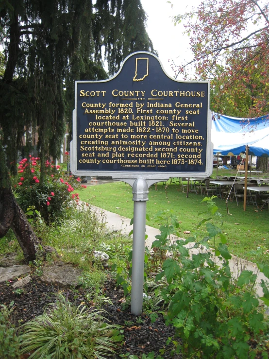 a sign on the side of the road with trees in the background