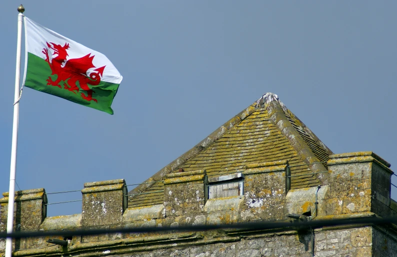 the national flag flies high above an old stone building