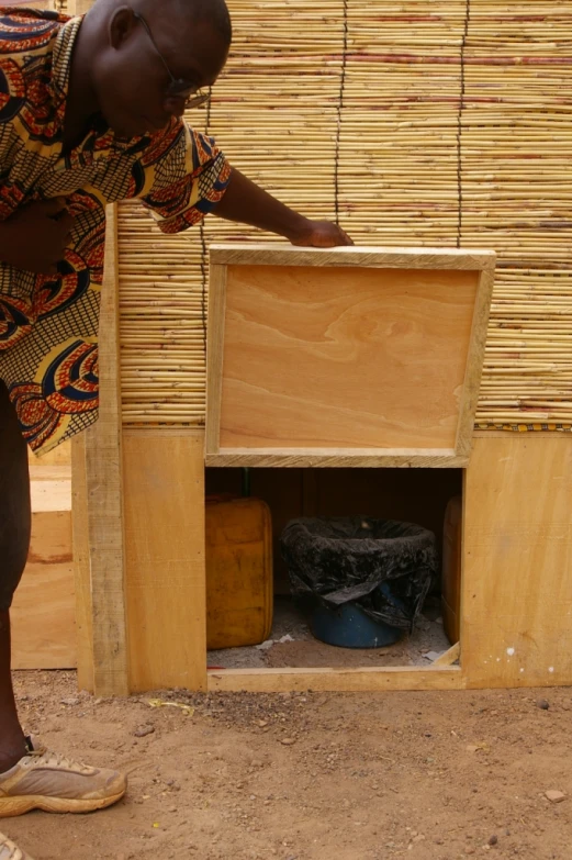 woman reaching into an open cubby on the ground