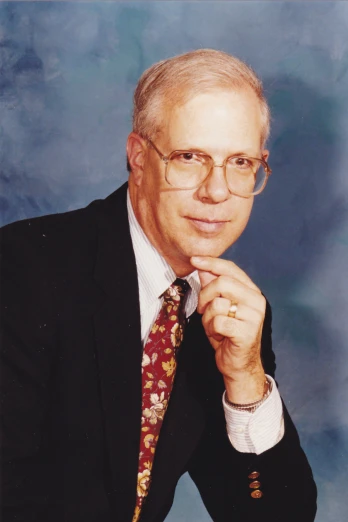 an older man with glasses and a tie