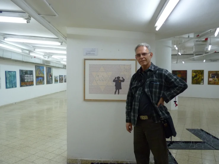 a man standing next to a white wall in a large room