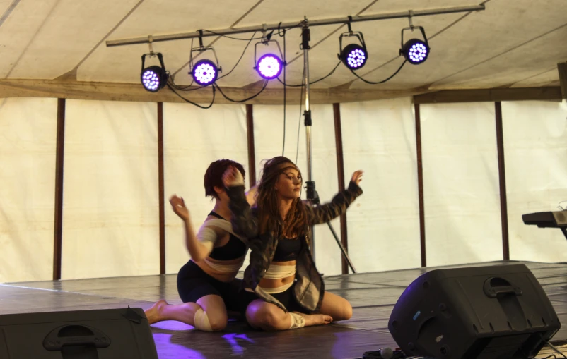 two people kneeling on the ground on stage