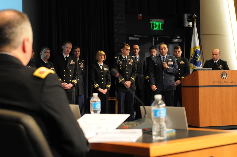 the military are standing behind a podium at a meeting