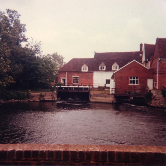 a water front with an old mill house on it