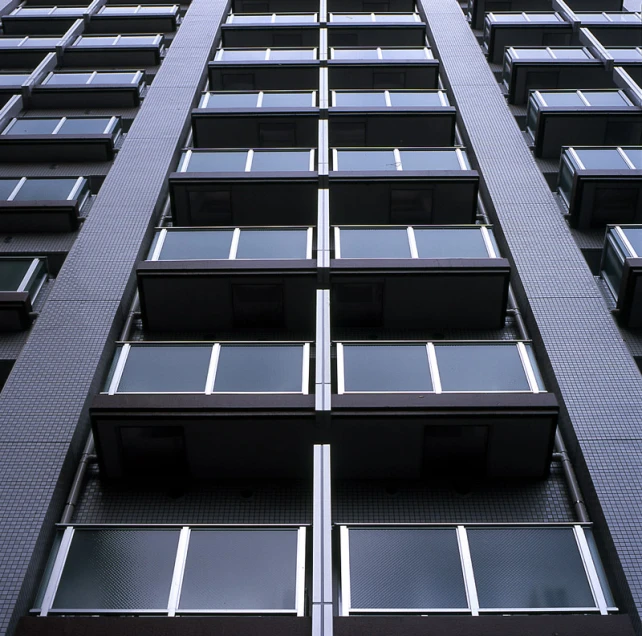 a very tall building with lots of windows next to a blue sky